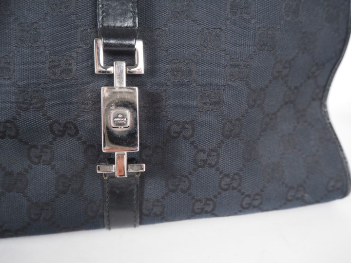 GUCCI Sac porté épaule, modèle "Jackie", en toile monogrammée noire.  