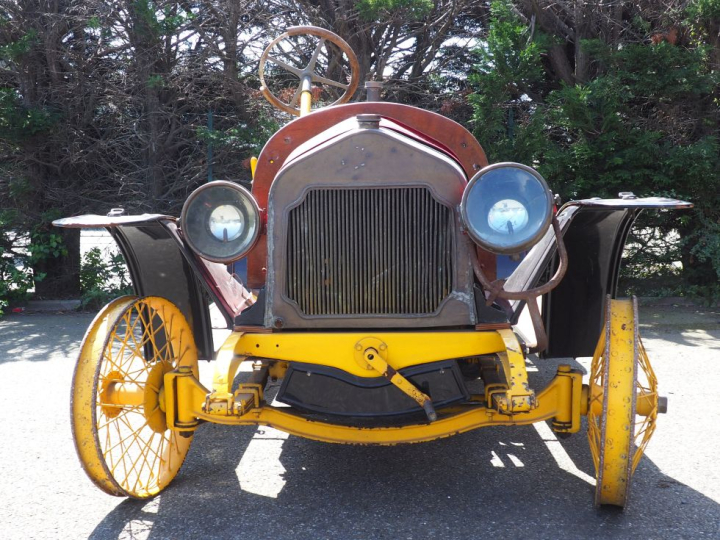 Base d'automobile début XXème avec différentes pièces dont moteur. (A 