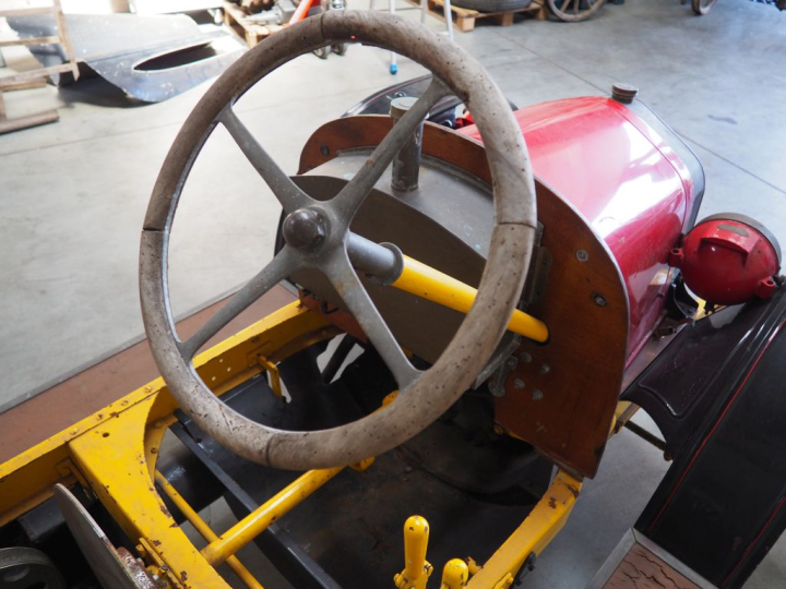 Base d'automobile début XXème avec différentes pièces dont moteur. (A 