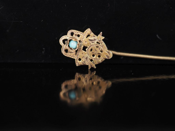 Ensemble comprenant :  - une broche en métal doré en forme de fleur, s