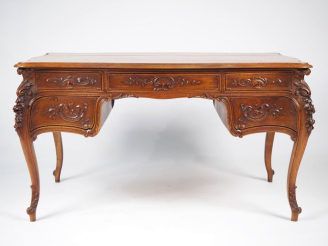 Vente aux enchères Bureau plat de style Louis XV en bois mouluré et sculpté, à décor de r