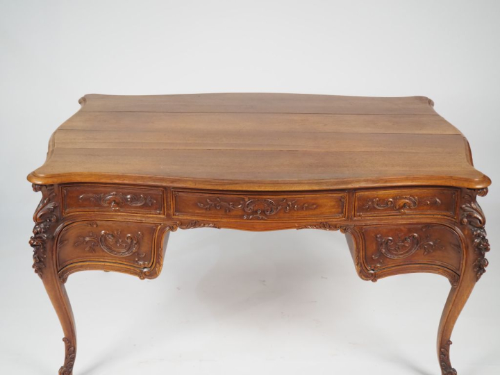 Bureau plat de style Louis XV en bois mouluré et sculpté, à décor de r