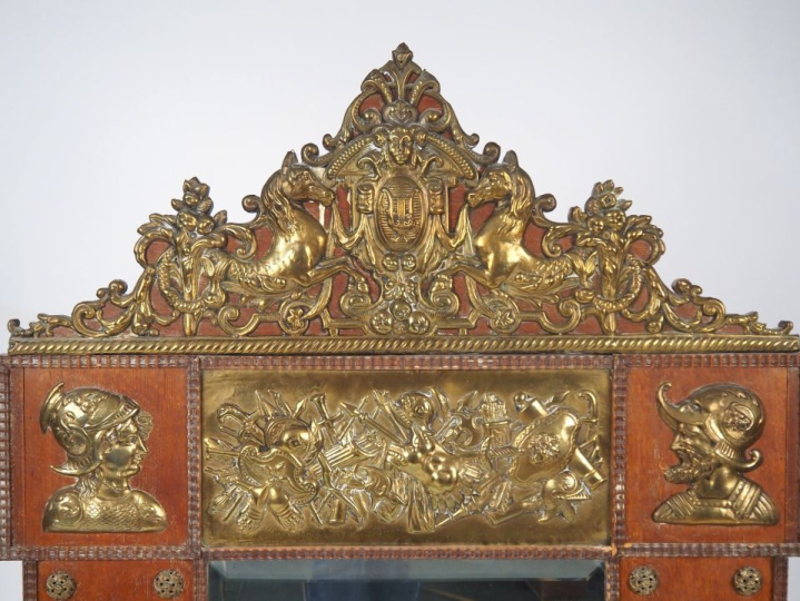 Glace de style Renaissance en bois et laiton, à décor en relief de gue
