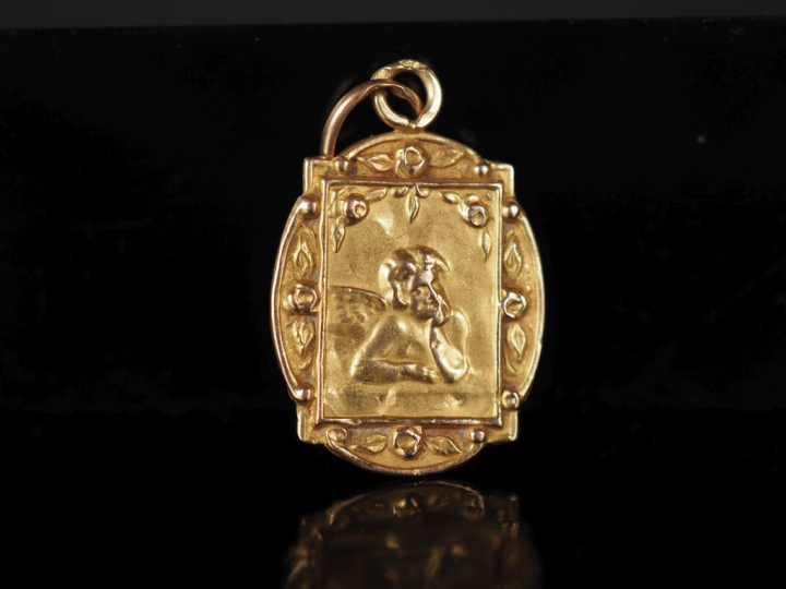 Médaille religieuse en or jaune 750, figurant un angelot.  Joli pourto