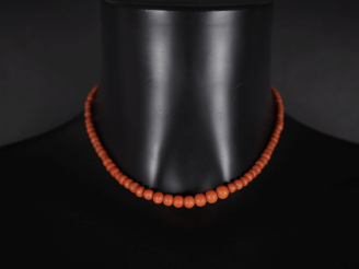 Vente aux enchères Collier de perles de corail disposées en chute.  Fermoir en or jaune 7