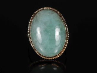 Vente aux enchères Bague en or jaune 375, sertie en son centre de jadéite en cabochon.  T