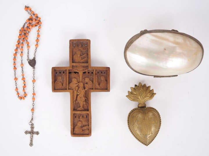 Croix en buis sculpté, un ex voto en laiton en forme de cœur enflammé,