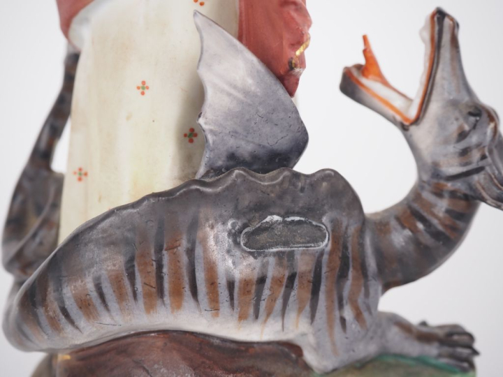 Sujet en biscuit polychrome "Sainte terrassant le dragon". (manques) H