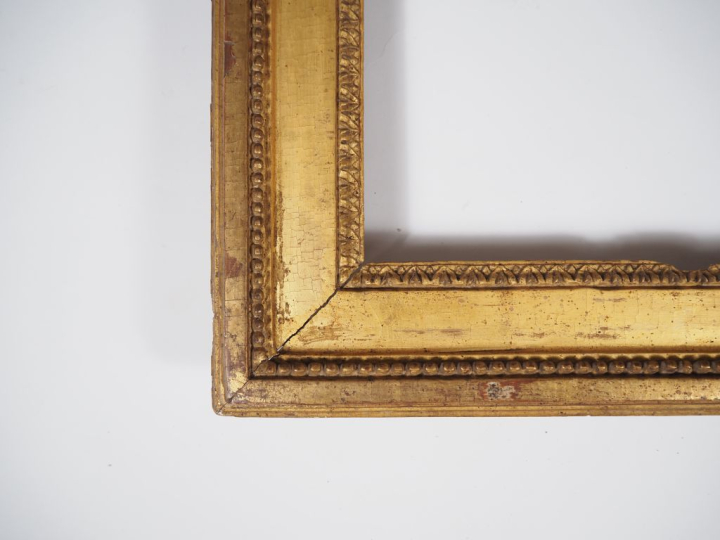 Cadre Louis XVI en bois sculpté et doré, à décor de perles et de feuil
