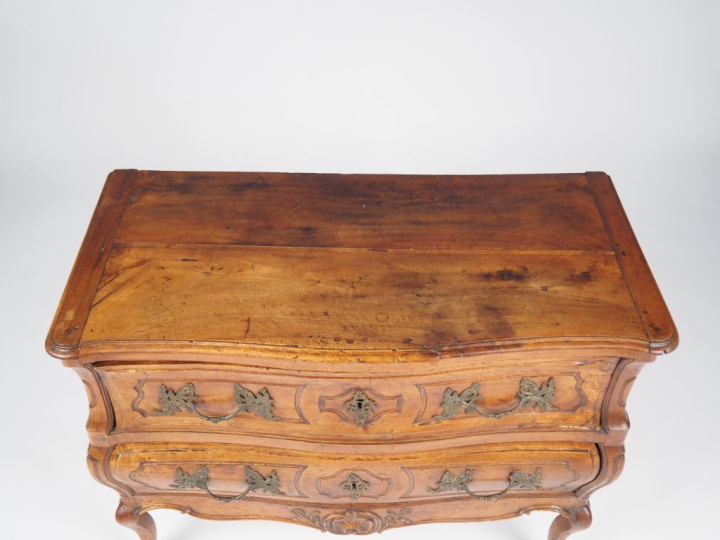 Commode Louis XV en noyer mouluré et sculpté, galbée sur les trois côt