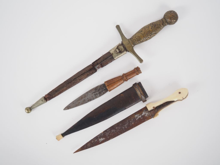 3 différents couteaux en métal, laiton, os et bois. L. de 17 à 34 cm.