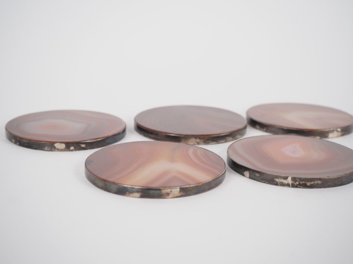 Suite de 5 dessous de verre en agate cerclés de métal argenté. Diam. 7
