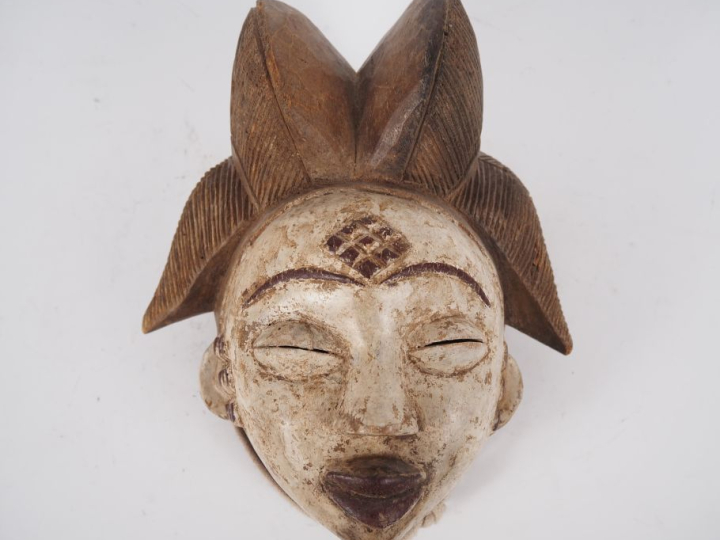 Masque de style Punu en bois sculpté polychrome. Dim. 26 x 22 cm.